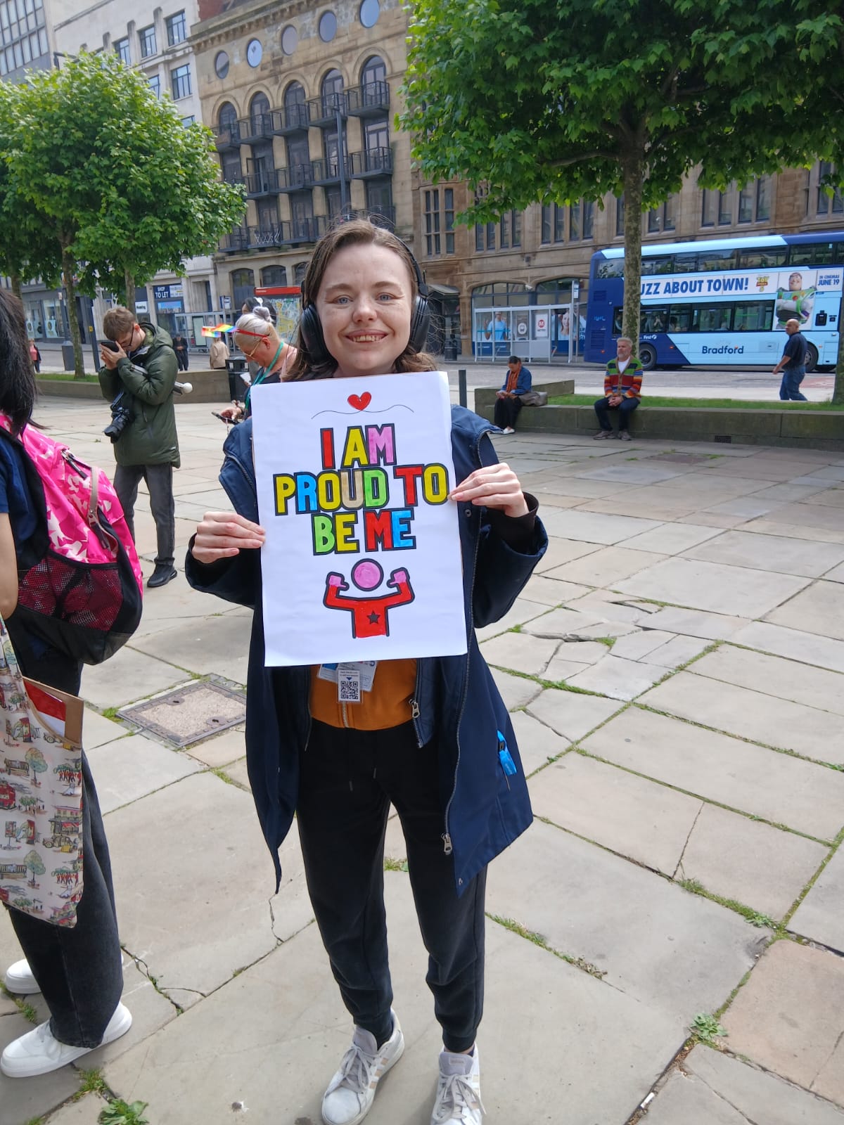 A photo of Angel from our team, holding a sign saying 'Proud to be me' at the Leeds Learning Disability Pride March in June 2026