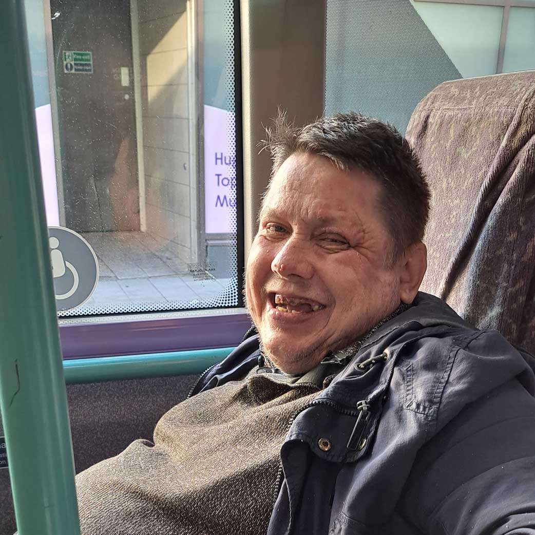 Client-on-bus Someone on a bus for a supported journey with our Travel with Confidence project.